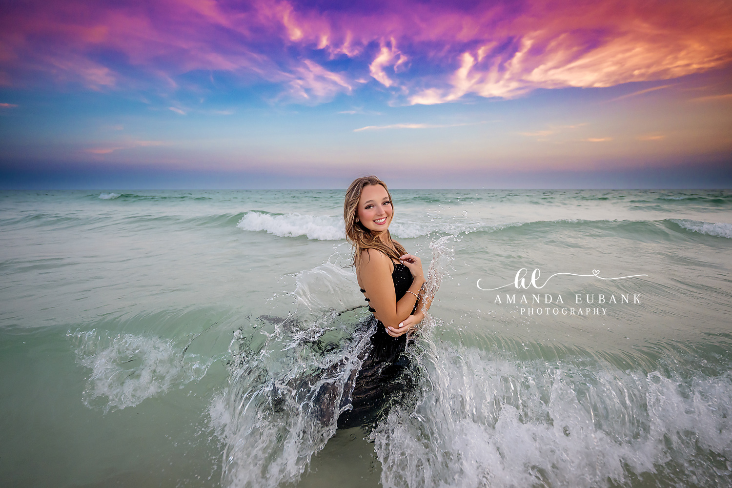Destin Florida senior photographer captures senior in black dress in crashing waves at sunset