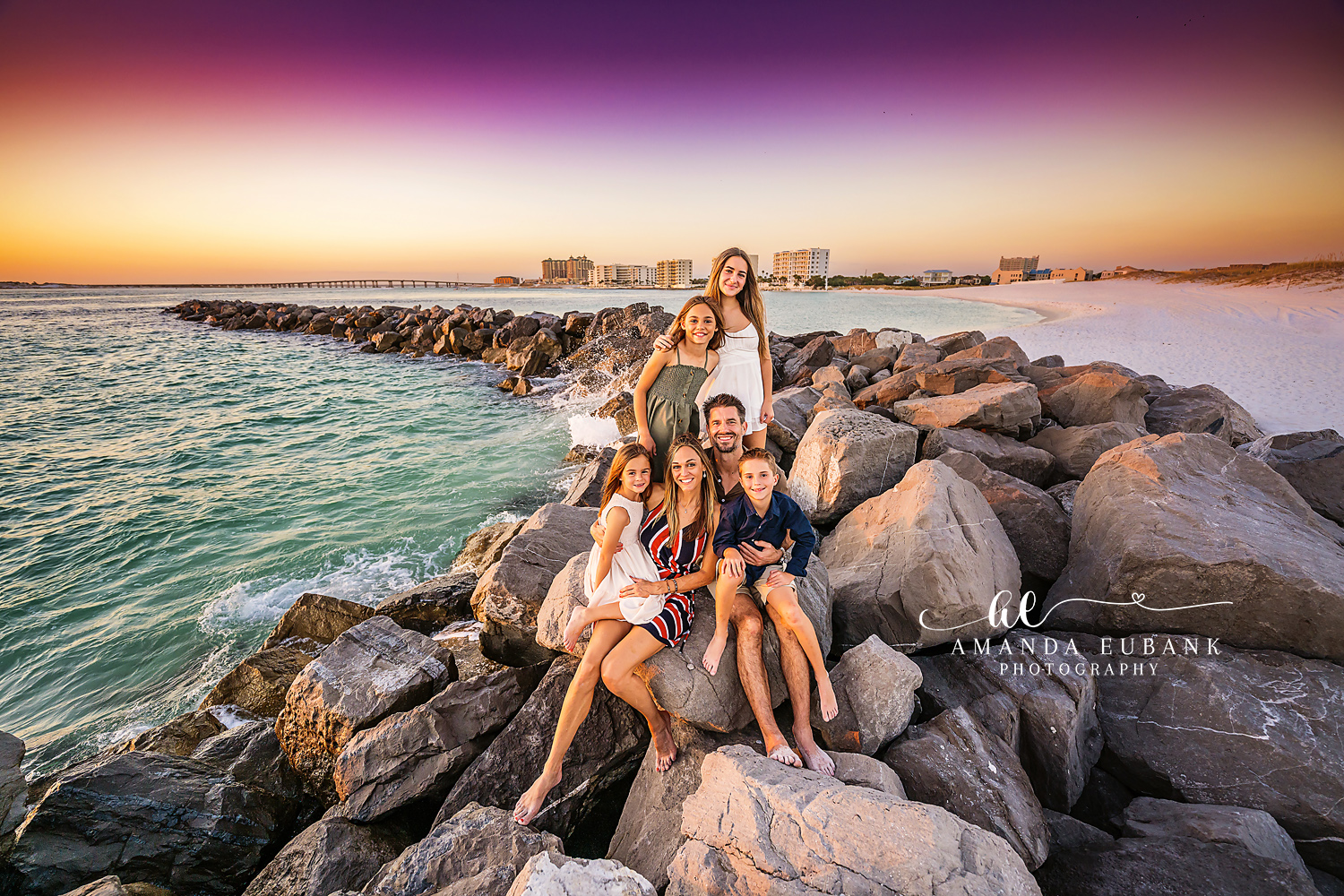 Destin family photographer captures family of six on harbor jetty at vibrant split sky sunset