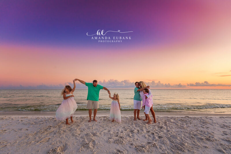 Destin family photographer captures family of six twirling girls in tutus on beach at pastel sunset
